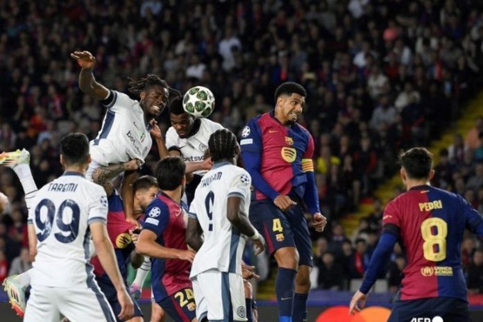 Bek Inter Milan Denzel Dumfries (2L) mencetak gol ketiga timnya selama pertandingan leg pertama semifinal Liga Champions UEFA antara FC Barcelona dan Inter Milan di Estadi Olimpic Lluis Companys di Barcelona pada tanggal 30 April 2025. (Foto oleh Josep LAGO / AFP)(AFP/JOSEP LAGO)