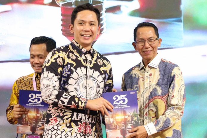 Wali Kota Batam, Amsakar Achmad, menerima buku 25 Praktik Terbaik Pemerintah Kabupaten saat menghadiri Rakernas APKASI XVII di Aston Hotel Batam, Minggu (18/1/2026) malam. HUMAS DISKOMINFO BATAM / DHEO ANANDA PUTRA