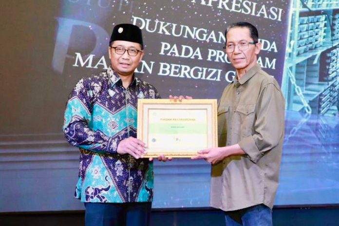 Kepala BPMP Kepri, Warsita, menyerahkan piagam penghargaan kepada Wali Kota Batam, Amsakar Achmad, Sabtu (14/2/2026) malam. HUMAS DISKOMINFO BATAM